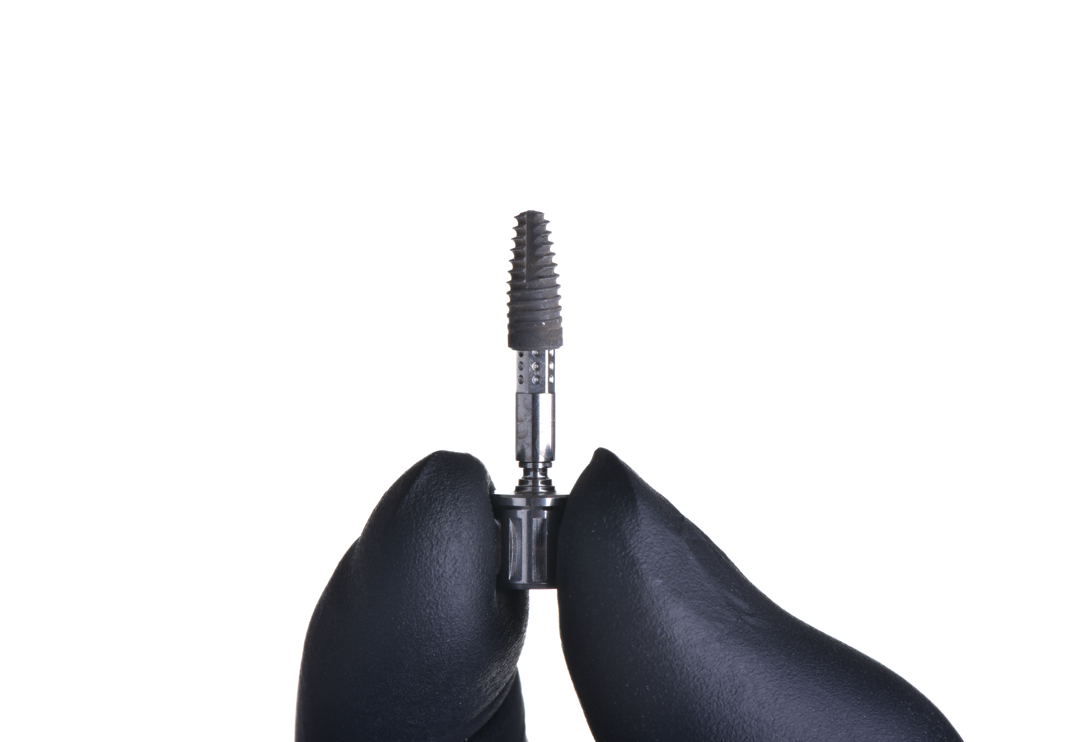 Straumann implant fixture close-up held by clinician at Eden Dental Office